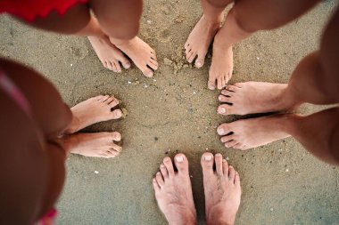 Çocuklar ve yetişkinler sahilde toplanır, ayaklarını sıcak kumun içine sokarlar..