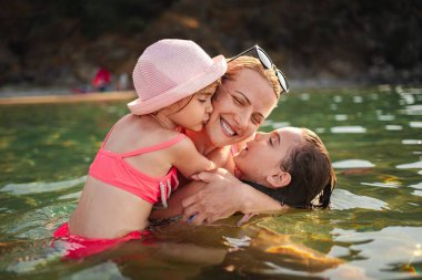 Bir anne ve iki kızı okyanusta süzülürken aynı kahkahayı ve sevgiyi paylaşıyorlar..