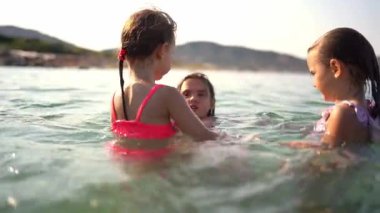 Mutlu çocuklar yaz tatillerinin tadını çıkarıyorlar, denizde oynuyorlar.