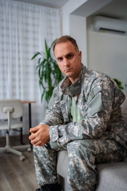 Depresyondaki asker evdeki kanepede oturuyor.