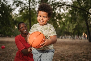 Sevimli küçük çocuk parkta annesiyle oynamaktan hoşlanıyor.