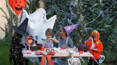 Fun group of children in halloween costumes playing and laughing together in a garden party