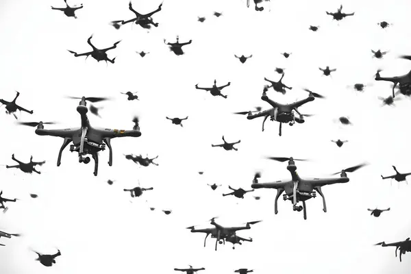 Gökyüzünde uçan çok sayıda dron yoğun ve kaotik bir sahne yaratıyor..