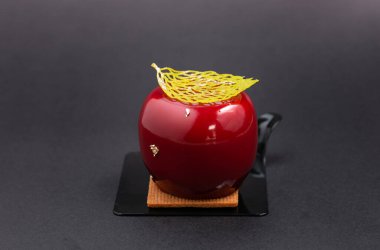 Kırmızı domates sosu, koyu arkaplanda siyah bir tabak dilimi.