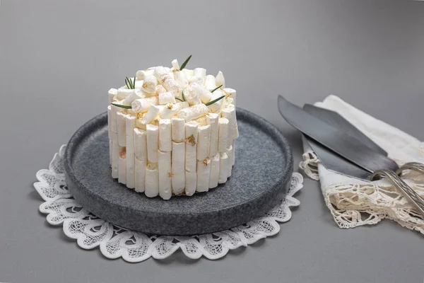Kremalı beyaz pasta ve gri arka planda bir fincan çay.