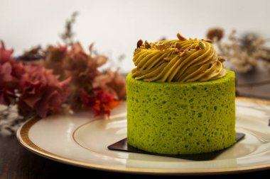 Bir tabak kremalı ve fındıklı yeşil çay keki.