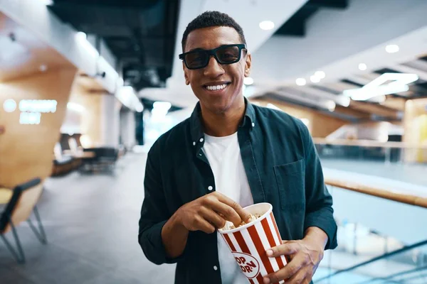 The man came to the meaning of the movie in the cinema with popcorn. High quality photo