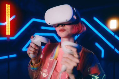 Genç bir kadın neon odada video oyunu oynuyor. Yüksek kalite fotoğraf