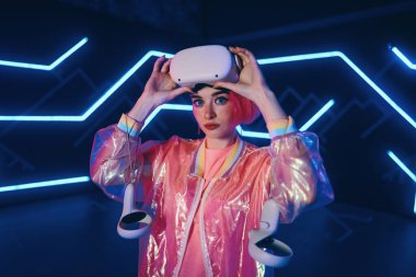 Genç bir kadın sanal oyunlar oynuyor. Video oyunları için neon oda. Yüksek kalite fotoğraf