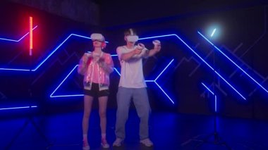 Genç bir kadın ve bir erkek VR oyunları oynuyorlar. İki oyuncu sanal dünyaya daldı. Yüksek kalite 4k görüntü
