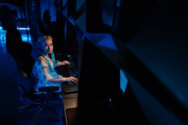Genç bayan blogcu, oyuncu bilgisayarda oyunlar oynuyor. Neon bilgisayar kulübü. Yüksek kalite fotoğraf