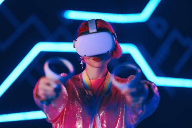 Pembeli genç bayan oyuncu sanal gerçeklik oyunları oynuyor. VR kulaklıklar ve kontrolörler. Yüksek kalite fotoğraf