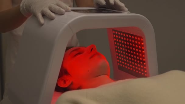 여자는 Led 램프를 얼굴의 피부를 절차를 받는다 고품질 — 비디오