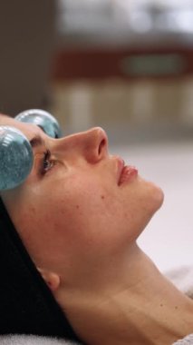 Usta, kadınların yüzüne kriosferlerin yardımıyla masaj yapıyor. Yüksek kalite 4k görüntü