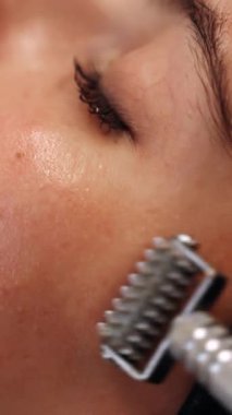 Serumu emmek için bir kadının yüzüne silindirle masaj yapmak. Yüksek kalite 4k görüntü