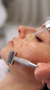 Serumu emmek için bir kadının yüzüne silindirle masaj yapmak. Yüksek kalite 4k görüntü