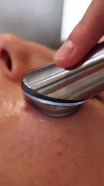 Bir kadın mikro akımlı bir aletle yüzüne masaj yapıyor. Yüksek kalite 4k görüntü