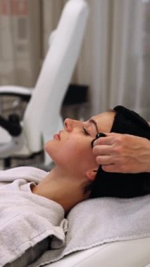 Bıyıklı kadın yüz masajı. Dikey video. Yüksek kalite 4k görüntü