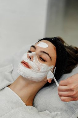 Profesyonel yüz bakımı. Bir usta güzellik salonunda bir kadının yüzüne masaj yapar. Yüksek kalite fotoğraf