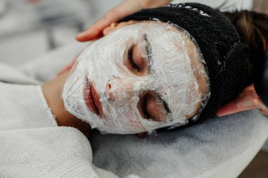 Profesyonel yüz bakımı. Bir usta güzellik salonunda bir kadının yüzüne masaj yapar. Yüksek kalite fotoğraf