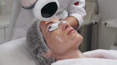 Bir profesyonel hasta kolundaki deriyi tedavi etmek için lazer uygular.