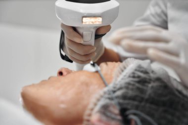 Bir profesyonel, klinikteki bir hastaya cilt bakımı sağlar.