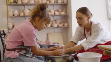 Bir çocuk, bir stüdyoda eğitmenin yanında çömlek tekniklerini de öğrenir..