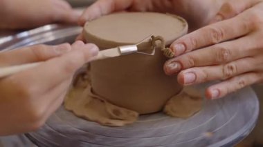 Katılımcılar, dost bir ortamda kil kullanarak çömlek parçaları oluşturuyorlar..