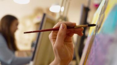 Bir sanatçı ustalıkla kapalı alanda çalışırken renkli bir manzara yaratır..