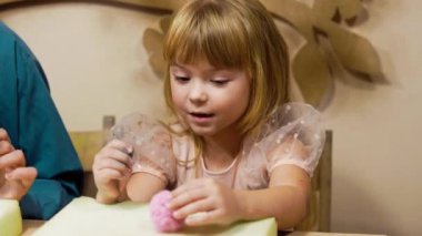 Genç bir kız neşeli bir şekilde renkli sanatsal faaliyetlere katılıyor..