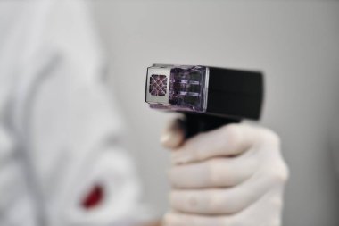 Bir sağlık çalışanı steril bir ortamda tıbbi bir araç tutar..