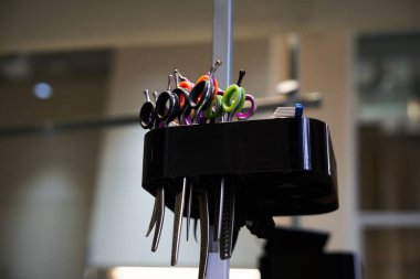 Çeşitli makas ve stil araçları bir kuaförde düzgünce düzenlenir.