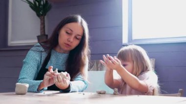 Ebeveyn ve çocuk rahat bir masada kilin kalıbını çıkarmaktan hoşlanırlar..