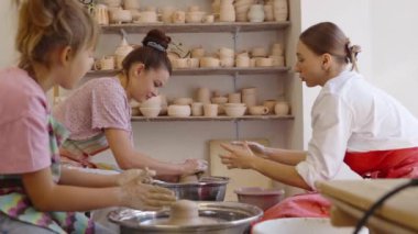 Katılımcılar eşsiz kil parçaları oluştururken çömlek tekniklerini öğreniyorlar.