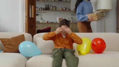 Bir çocuk sürpriz bir doğum günü kutlaması için balonlarla hazırlanır..