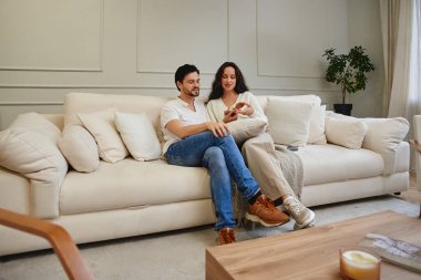 Çift, koltukta otururken sıcak ve samimi bir anı paylaşıyor..