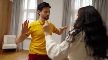 Bir çift rahat bir odada canlı bir dans pratiği yapıyor..