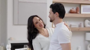 Bir çift evlerindeki oturma odalarında dans ederken keyifli bir anı paylaşıyor..