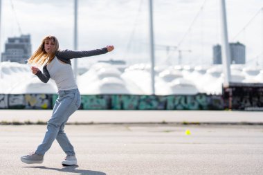 Genç bir kadın şehirde hareketli bir dans gösterisi sergiliyor..