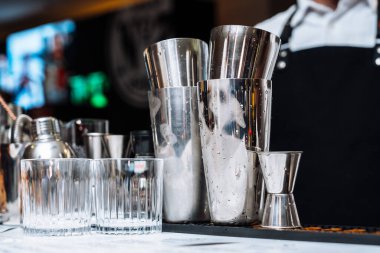 Bir tatma etkinliğinde çeşitli karıştırma araçları ve bardaklarla kokteyl hazırlamak.