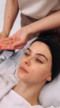 Becerikli bir profesyonel, bir hastaya gençleştirici cilt bakımı uygular.