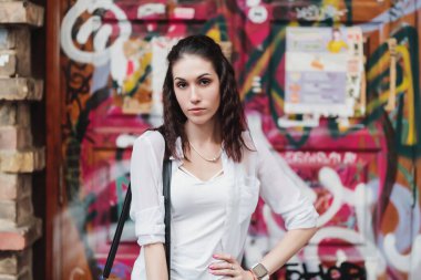 Genç bir kadın hayat dolu sokak sanatı ile rahat bir şekilde poz veriyor..