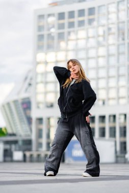 Bir dansçı eşsiz dansını öğleden sonra saatlerinde modern bir şehirde sergiliyor..