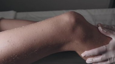 Eğitimli bir profesyonel, kas gerilimini azaltmak için hastaların bacağına derin doku teknikleri uygular..