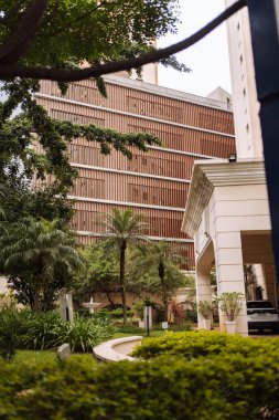 Yeşillik bitkiler, kendine özgü ahşap aksanları olan modern bir şehir yapısını çevrelemektedirler..