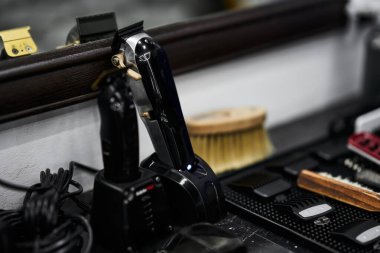 Elektrikli makas ve bakım aletleri kullanımdan sonra bir berber tezgahında dinleniyor.