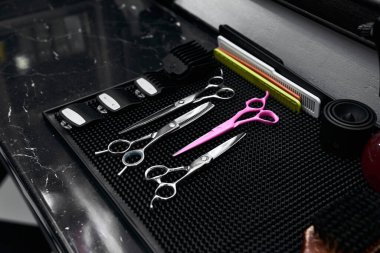 A selection of hair cutting scissors, combs, and clipper accessories neatly organized in a salon. clipart