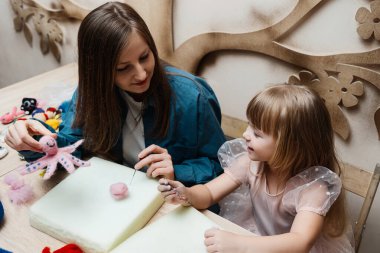Bir anne kızına evde eğlenceli bir zanaat projesinde yardım eder..