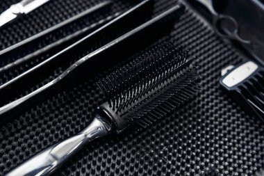 Kuaförde koyu renk iş yüzeyinde çeşitli saç şekillendirme araçları düzenli olarak düzenlenir..