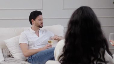 Bir çift, dinlenme odalarında şarap yudumlarken samimi bir tartışmanın tadını çıkarıyor..